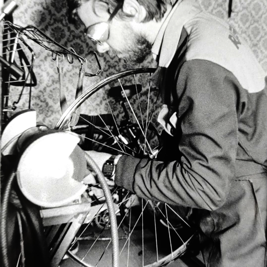 Hier zie je Mattheus Briers die een fiets aan het herstellen is in de herstelplaats van Fietsen MB in 1977